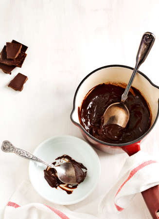 Molten chocolate in small pan and pieces of chocolate barの写真素材