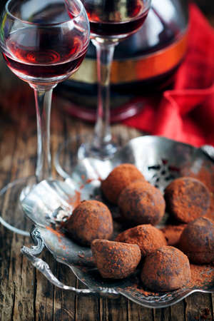 Dark chocolate truffles and two glasses of raspberry  liqueurの写真素材