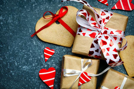 Gift box with decorative red hearts and heart shaped cookies. Festive background. Flatlay with copy space.の写真素材