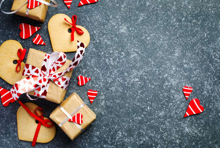 Gift boxes with decorative red hearts and heart shaped cookies. Festive background. Flatlay with copy space.の写真素材