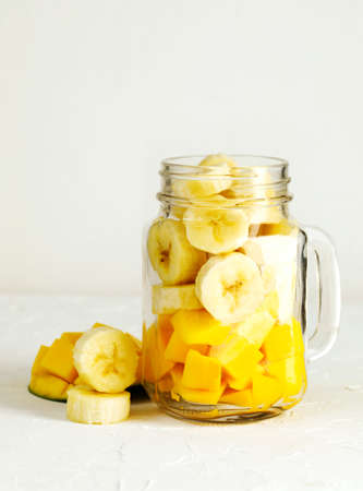 Ingredients for Mango Banana Smoothie in mason jar. Healthy vegan eating.の写真素材