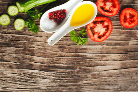 Fresh vegetables, olive oil, herbs and spices on wooden background, top viewの写真素材