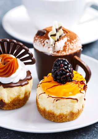 Small pastries. Mango cheesecake, classic cheesecake, coffee mousse in chocolate cupの写真素材