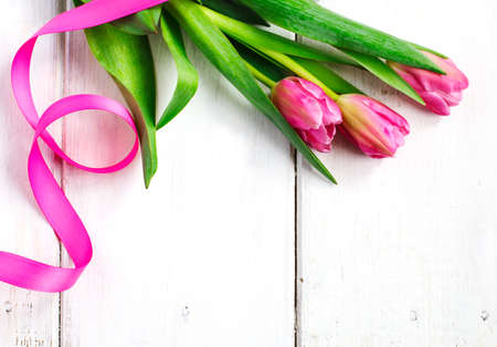 Spring tulips on white wooden background, top viewの写真素材
