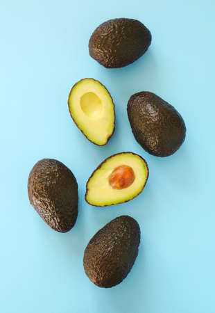 Avocado halves and whole on a blue speckle, top viev.の写真素材