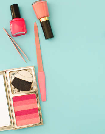 Beauty flat lay with woman make up products and accessories in pink color. Woman make up products and accessories in pink color on pastel light blue background, top viewの写真素材
