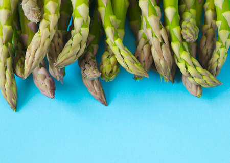 Fresh  raw asparagus on light blue background, copy spaceの写真素材