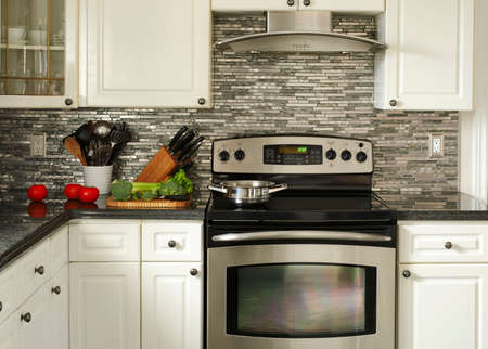 Electric Stainless steel stove, kitchen utensils and vegetables on the cooking tableの写真素材