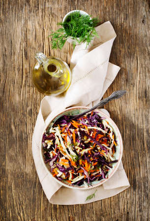 Fresh Coleslaw Salad served in bowl on wooden table, top viewの写真素材