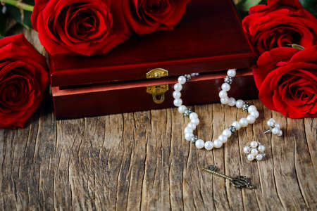 Fresh red roses with pearls on wooden background, copy spaceの写真素材