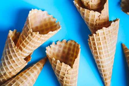 Sweet wafer cone for ice cream on blue background, top viewの写真素材