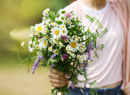 A young girl holding a bouquet of wildflowers in handsの写真素材