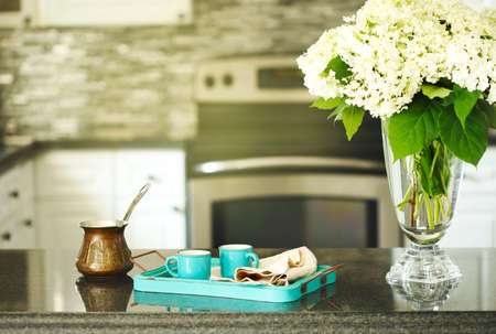 Two cups of coffee, copper cerve and bouquet of hydrangea on kitchen tableの写真素材