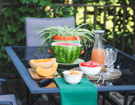 Fruits and grapefruit juice in jug on the table at garden.の写真素材