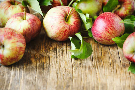 Apples with leaves on wooden background with copy spaceの写真素材
