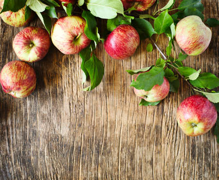 Apples with leaves on wooden background with copy spaceの写真素材