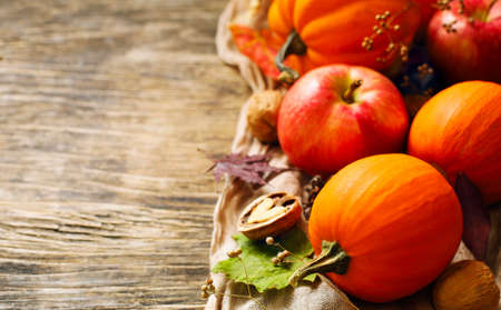 Autumn pumpkins and apples with fall leaves on wooden background with copy space. Autumn composition.の写真素材