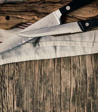 Old knives and Chopping board on wooden background, top view, copy spaceの写真素材