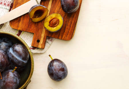 Fresh plums in bowl on wooden table, top view, copy spaceの写真素材