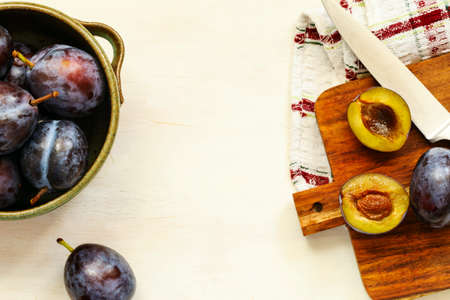 Fresh plums in bowl on wooden table, top view, copy spaceの写真素材