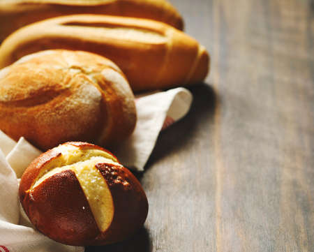 Assortment of baked bread on wooden table backgroundの写真素材
