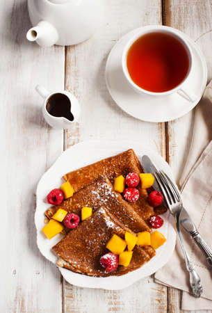 Crepes with fresh mango and raspberriesの写真素材