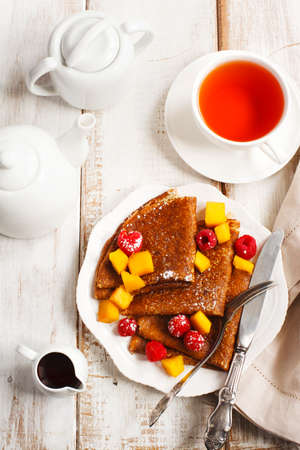 Crepes with fresh mango and raspberriesの写真素材