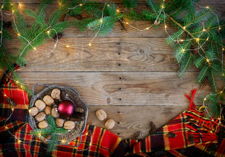 Christmas flat lay frame with a lights, fir branches, baublesand  plaid. Winter holiday concept composition, copy spaceの写真素材