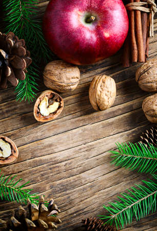 Christmas holiday background with fir branches, apples and nuts.  Winter holiday conceptの写真素材