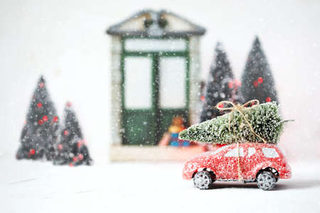 Red retro toy car delivering Christmas Tree. Holiday cardの写真素材