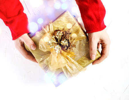 Girl hands holding present for Christmas. Top view.の写真素材