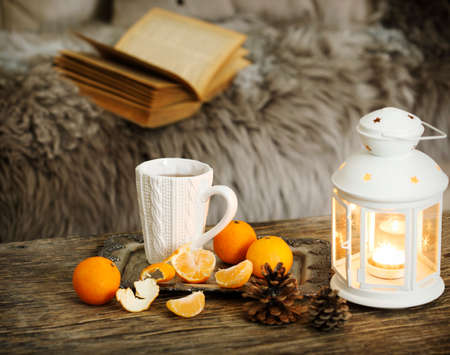 Cup of tea and candles on wooden table near the sofaの写真素材