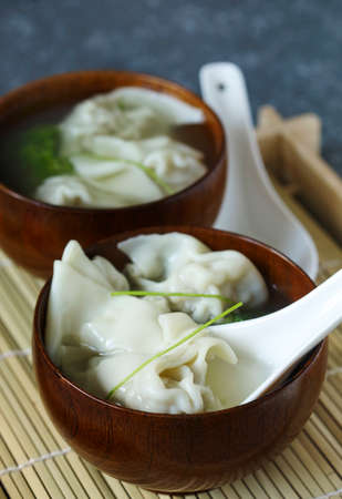Chinese wonton soup with pork in wooden bowlの写真素材
