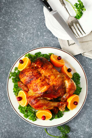 Roasted chicken served with citrus and cranberry on plate, top view, copy spaceの写真素材