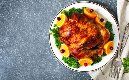 Roasted chicken served with citrus and cranberry on plate, top view, copy spaceの写真素材
