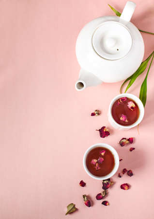 Herbal tea with roses on pink background, top view, copy spaceの写真素材