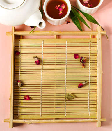 Herbal tea with roses on pink background, top view, copy spaceの写真素材