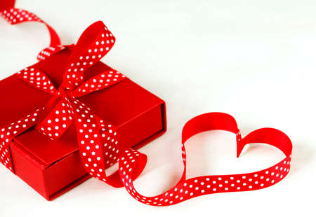Gift box with red bow ribbon on white background for Valentines day, copy spaceの写真素材