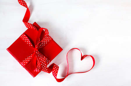 Gift box with red bow ribbon on white background for Valentines day, copy spaceの写真素材