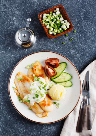 Fried Basa Fillet with sauce, mashed potato and fresh vegetables, top viewの写真素材