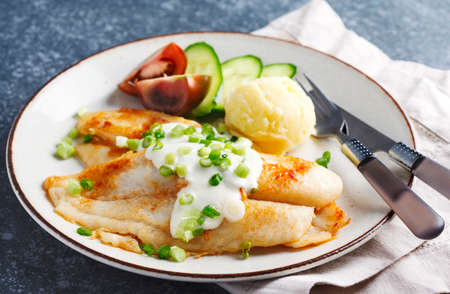 Fried Basa Fillet with sauce, mashed potato and fresh vegetablesの写真素材