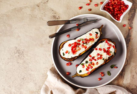 Baked eggplants with garlic yogurt sauce and pomegranate, top view, copy spaceの写真素材