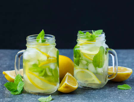 Mason jar glass of lemonade with mint on blue stone background.の写真素材