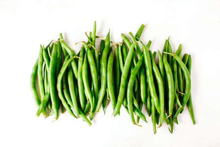 Green beans on white wooden background. Top view. 