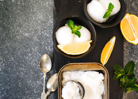 Lemon ice cream in black bowl, copy space