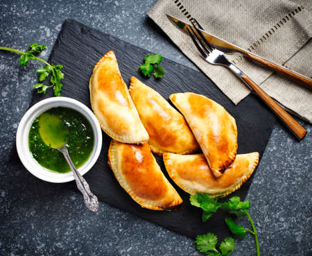 Empanadas with chimichurri sauce. Traditional Latin American cuisine. Top view.の写真素材