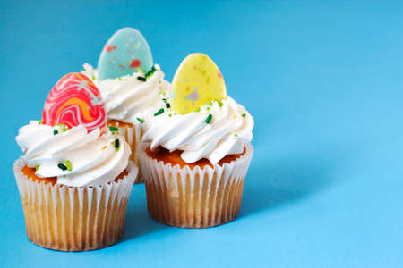 Easter vanilla cupcakes on blue background, copy spaceの写真素材