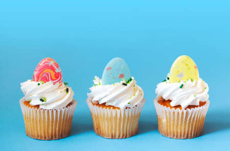 Easter vanilla cupcakes on blue backgroundの写真素材