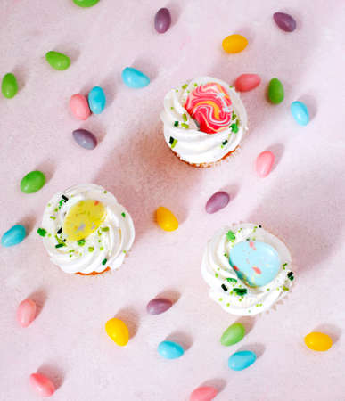 Easter vanilla cupcakes on pink background, top view