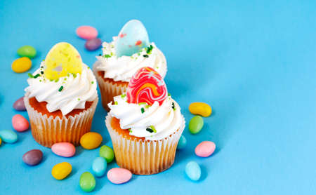 Easter vanilla cupcakes on blue background, copy spaceの写真素材